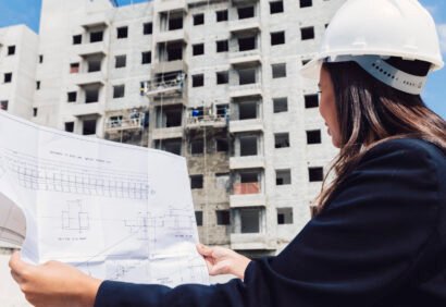 african-american-lady-safety-helmet-with-paper-plan-near-building-construction african-american-lady-safety-helmet-with-paper-plan-near-building-construction